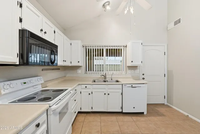 a kitchen with a sink a stove and cabinets
