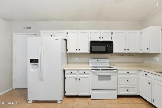 a kitchen with white cabinets and white appliances