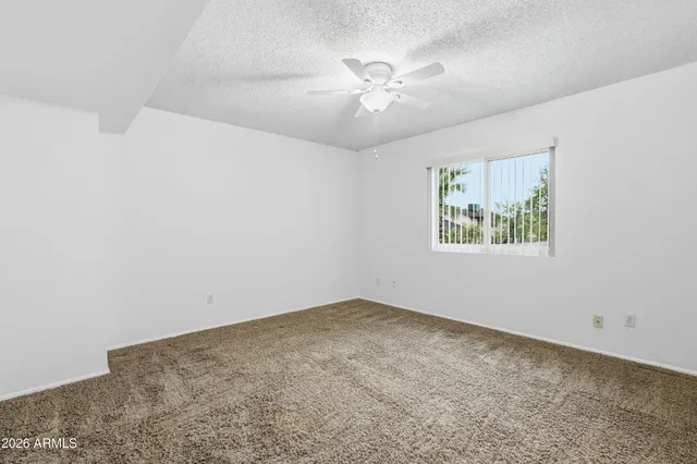 a view of an empty room with chandelier fan