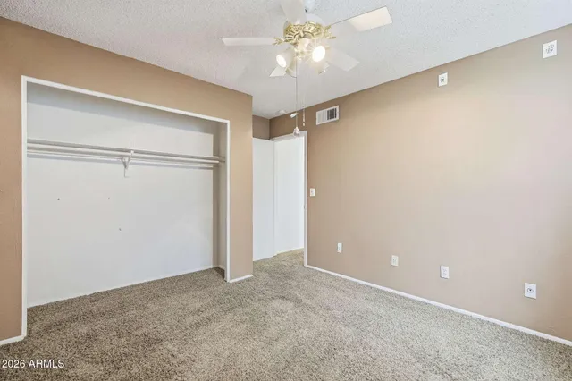 an empty room with a ceiling fan and a window