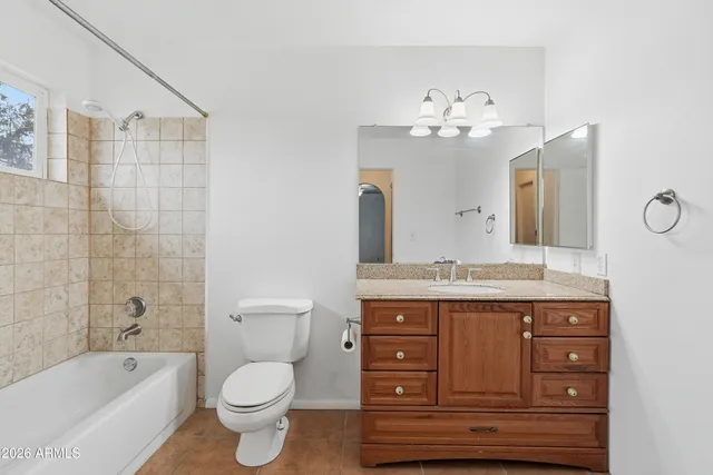 a bathroom with a granite countertop toilet sink and mirror
