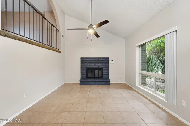 a view of an empty room with a fireplace and a window