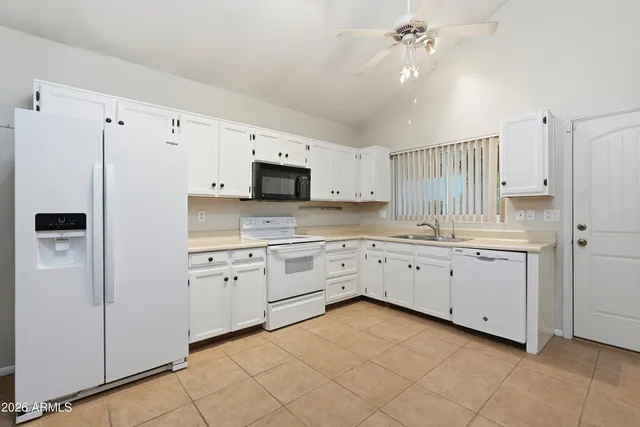 a kitchen with white cabinets and white appliances
