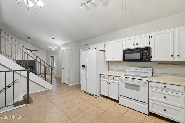 a kitchen with white cabinets and white appliances