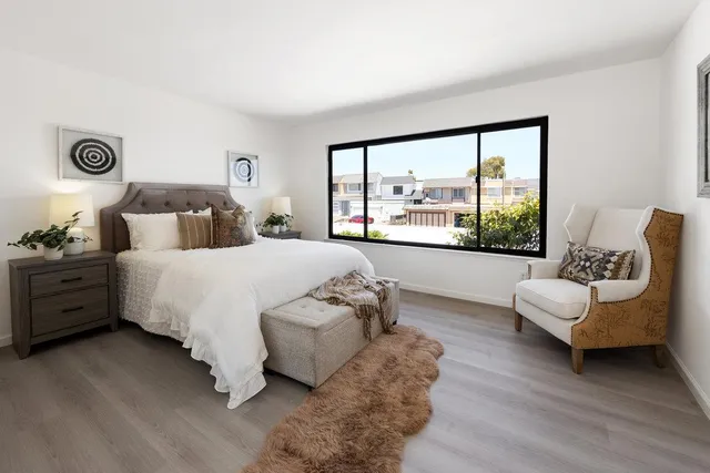 a bedroom with a bed and a large window