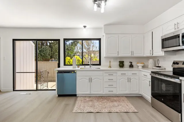 a kitchen with granite countertop a refrigerator stove top oven and sink