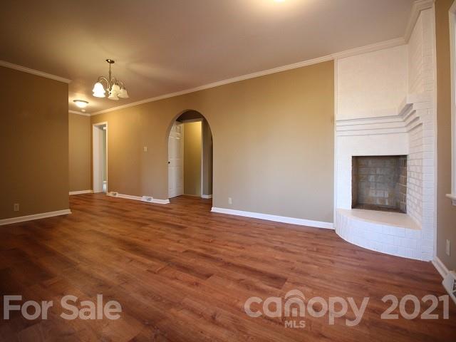 166 Cemetery Street Chester, SC 29706 - Photo 6 of 28 an empty room with wooden floor and chandelier