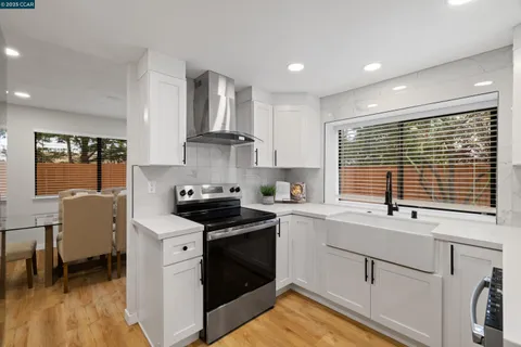 a kitchen with stainless steel appliances granite countertop a sink stove and cabinets