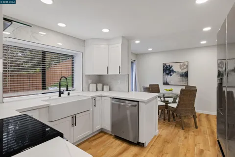 a kitchen with a sink cabinets and wooden floor