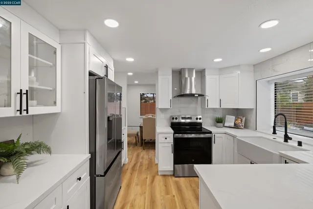 a kitchen with a sink a counter top space stainless steel appliances and cabinets