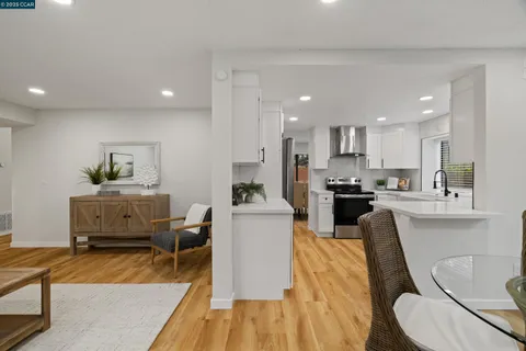 a living room with furniture and a dining table with kitchen view