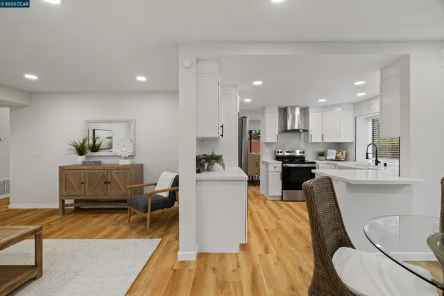 a living room with furniture and a dining table with kitchen view