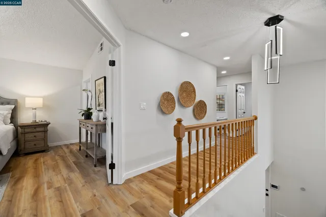 a view of a hallway with a white furniture and wooden floor