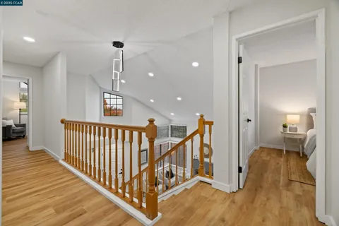a view of a hallway with wooden floor and stairs