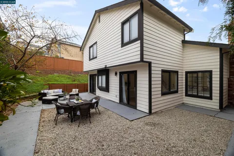 a view of a house with backyard and sitting area
