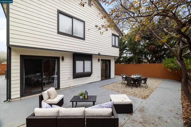 a view of a patio with couches table and chairs and potted plants