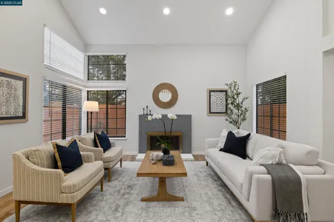 a living room with furniture a fireplace and a large window