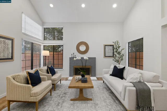 a living room with furniture a fireplace and a large window