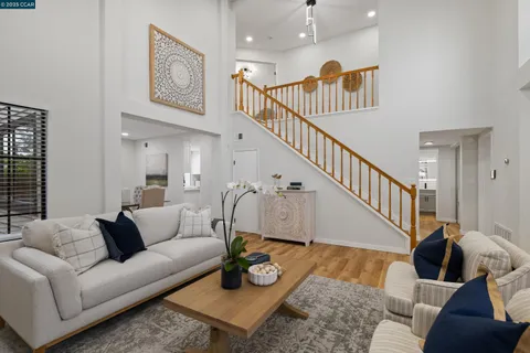 a living room with furniture and a dining table with wooden floor