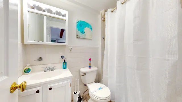 a bathroom with a sink a toilet and a mirror