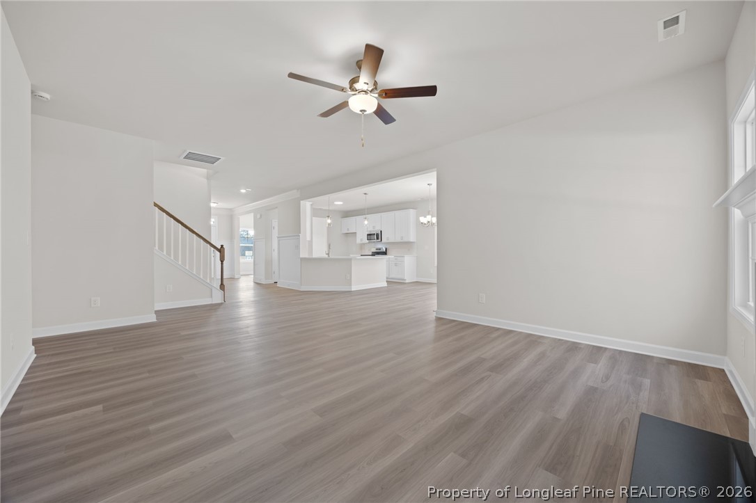 147 Michter Street Vass, NC 28394 - Photo 35 of 48 a view of an empty room with wooden floor and a ceiling fan