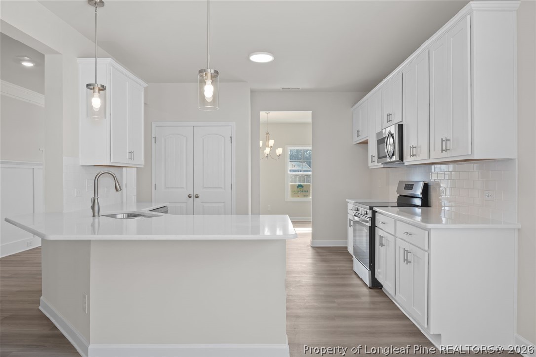 147 Michter Street Vass, NC 28394 - Photo 40 of 48 a large white kitchen with kitchen island a sink stainless steel appliances and cabinets