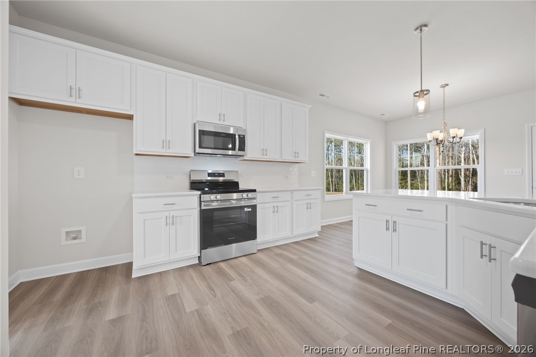 147 Michter Street Vass, NC 28394 - Photo 43 of 48 a kitchen with granite countertop white cabinets and stainless steel appliances