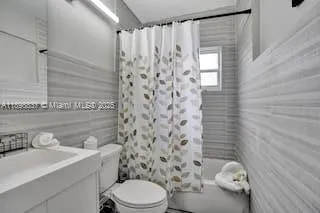 a bathroom with a shower curtain sink and a toilet
