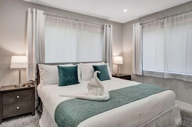 a bedroom with a large bed and a chandelier