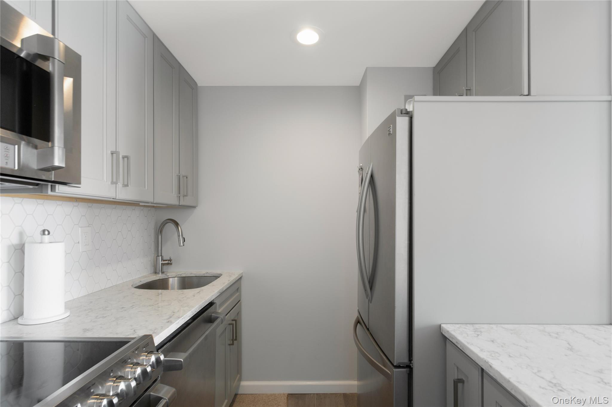 2 Richmond Road, Unit 3A Lido Beach, NY 11561 - Photo 16 of 33 a kitchen with stainless steel appliances granite countertop a refrigerator and a sink
