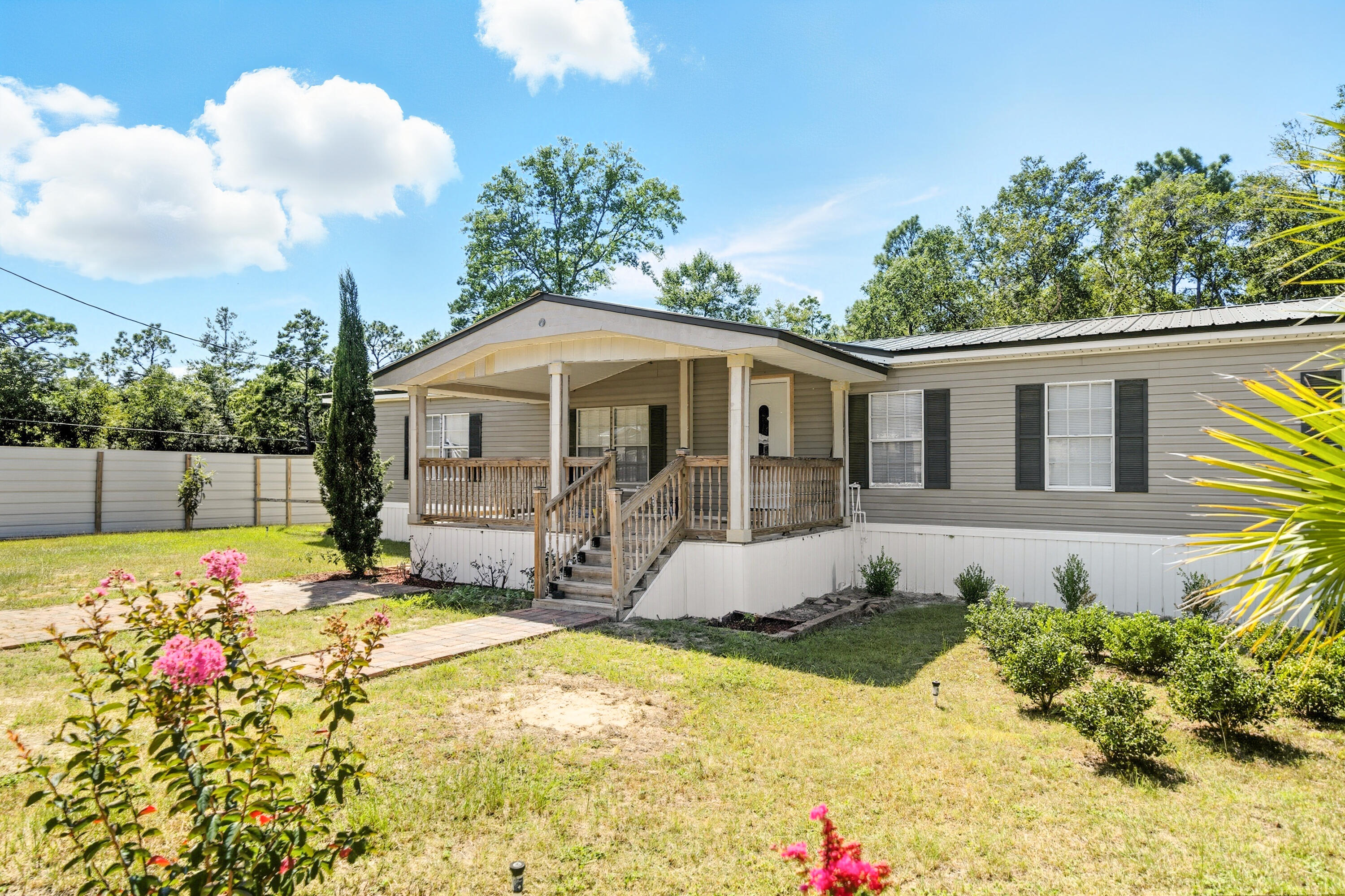 714 East Picasso Road DeFuniak Springs, FL 32433 - Photo 2 of 25 a front view of house with yard outdoor seating and barbeque oven