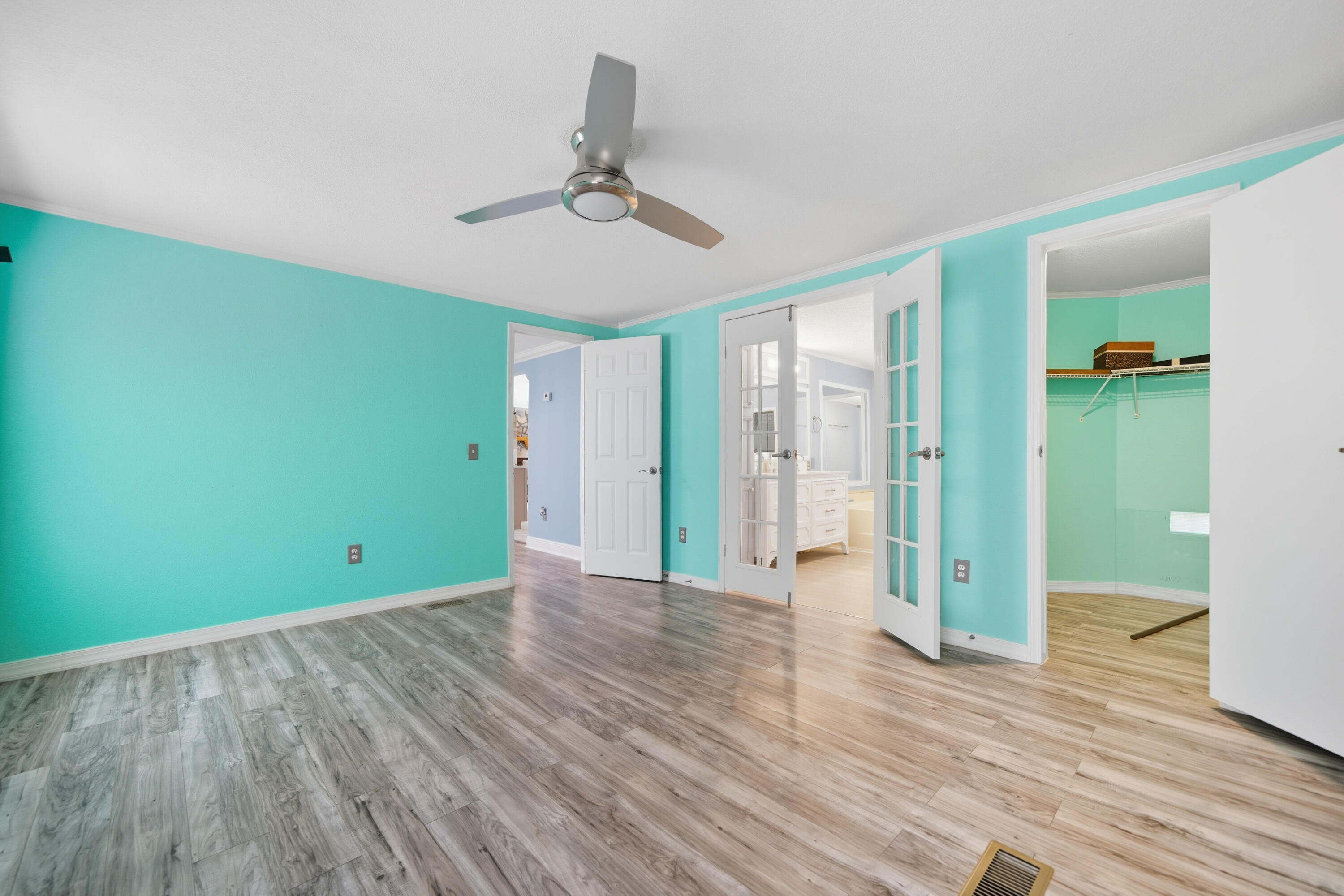 714 East Picasso Road DeFuniak Springs, FL 32433 - Photo 24 of 25 a view of an empty room with wooden floor and a ceiling fan