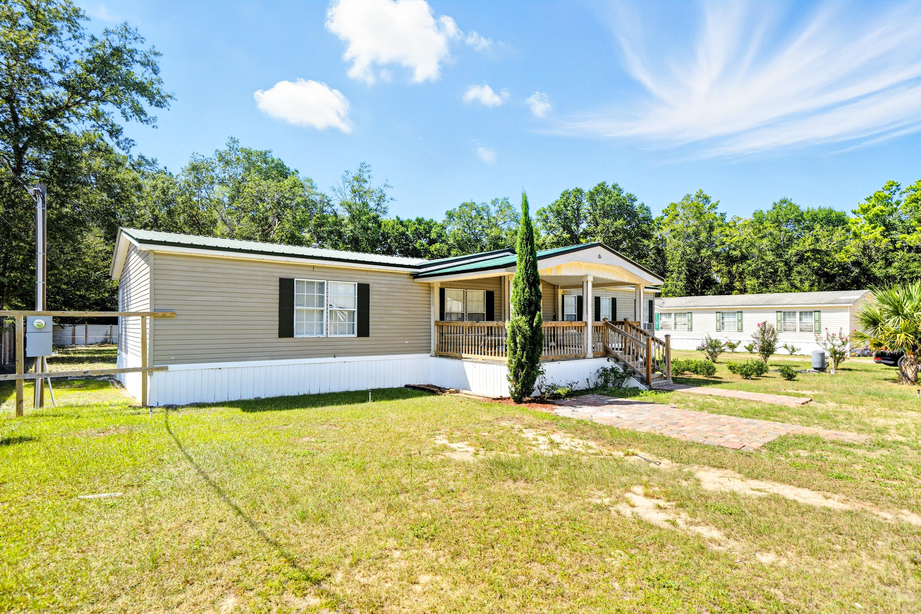 714 East Picasso Road DeFuniak Springs, FL 32433 - Photo 3 of 25 a view of a house with a big yard and large trees