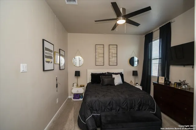 a bedroom with a bed and a flat tv screen on the dresser