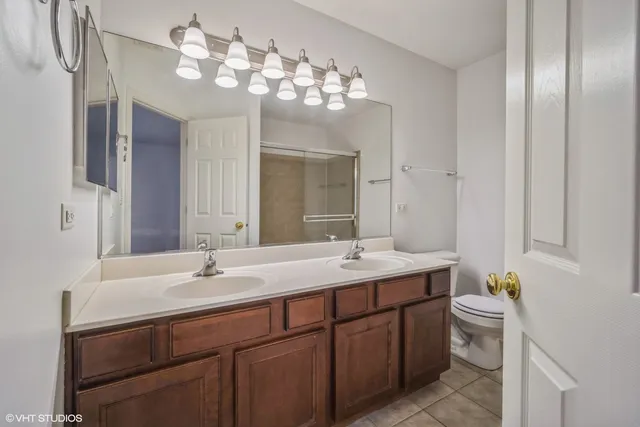a bathroom with a double vanity sink mirror and toilet