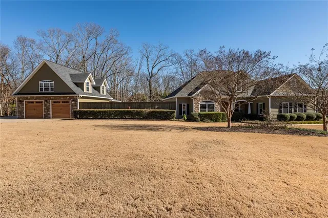 a front view of a house with a yard covered in snow