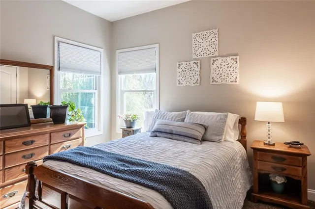 a bedroom with a bed and a flat tv screen on the dresser