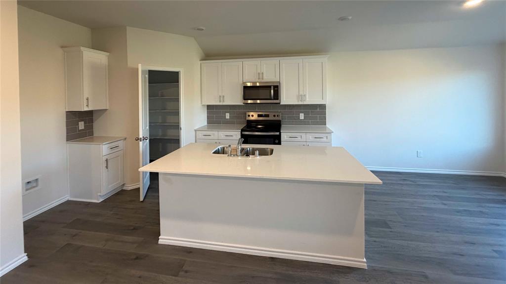 1550 Brooke Drive Tyler, TX 75704 - Photo 3 of 17 a kitchen with a sink a microwave a refrigerator and cabinets