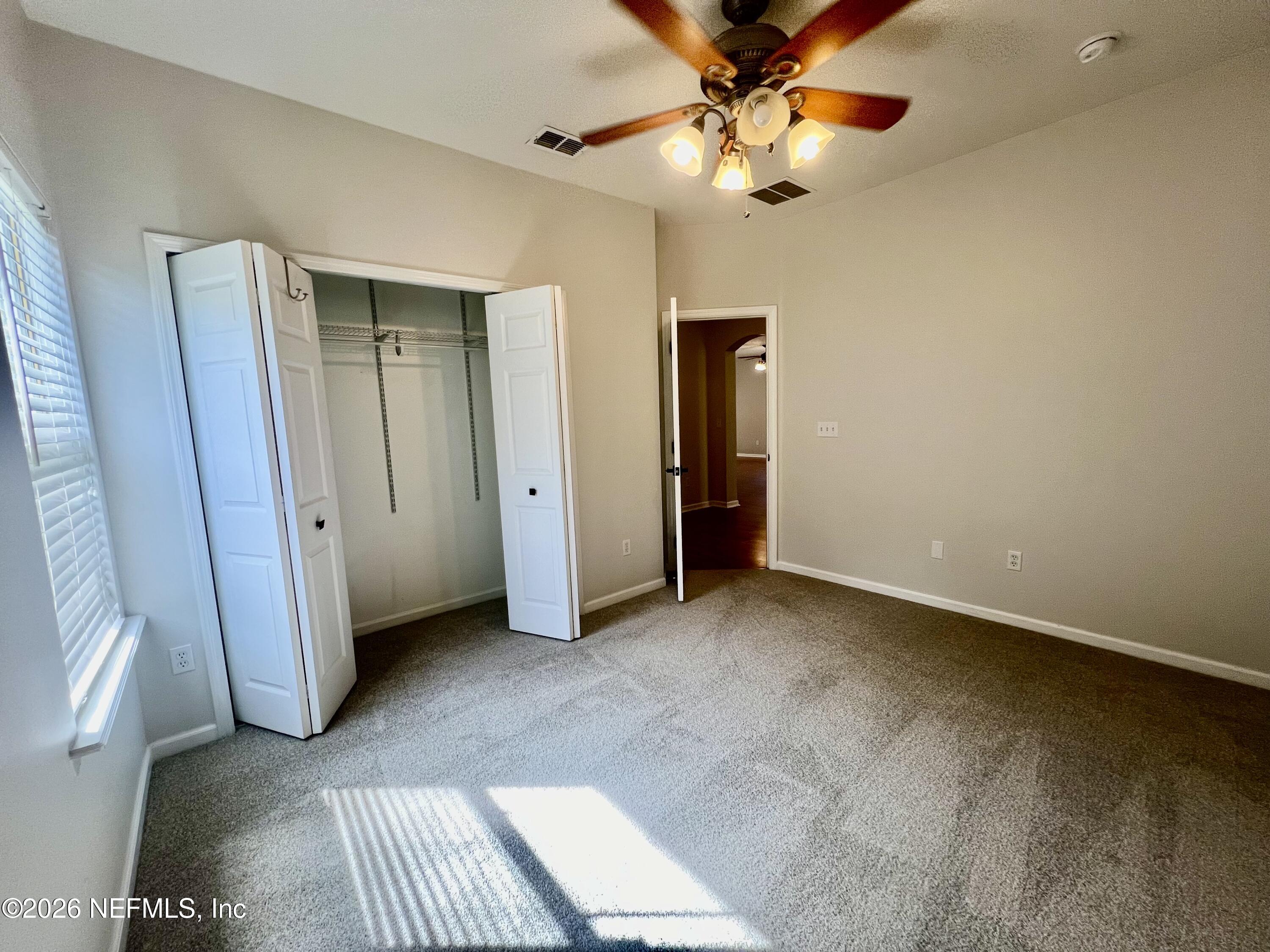 5410 Turkey Creek Road Jacksonville, FL 32244 - Photo 33 of 48 an empty room with closet and a chandelier fan