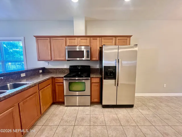 a living room with furniture a ceiling fan a flat screen tv and a large window