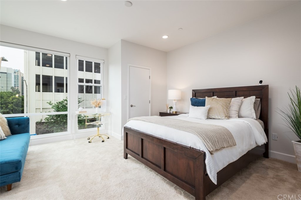 201 Elm Avenue Long Beach, CA 90802 - Photo 9 of 23 a spacious bedroom with a bed a couch and a bookshelf