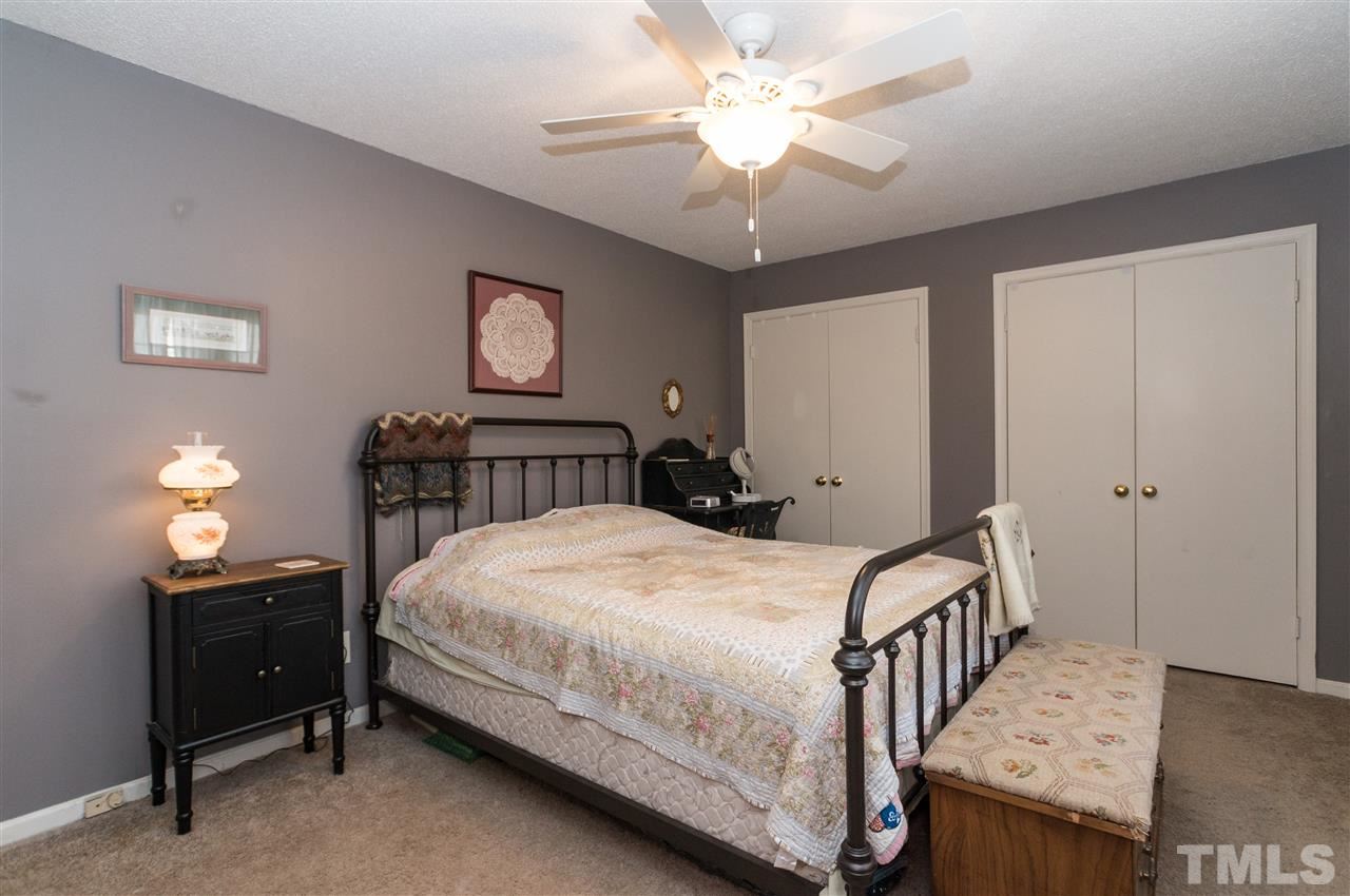 1108 Mockingbird Drive Raleigh, NC 27615 - Photo 11 of 21 a bedroom with a bed a chandelier and dresser