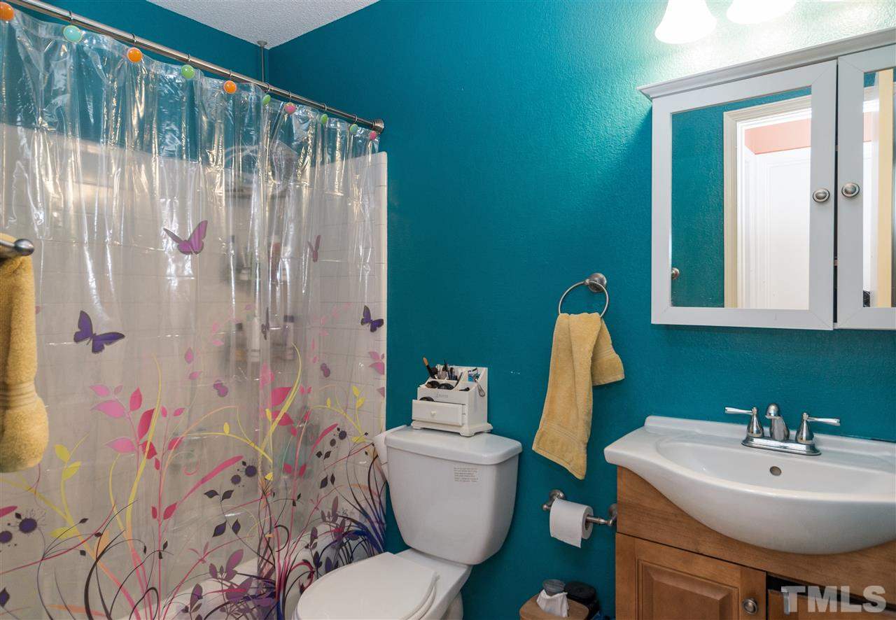 1108 Mockingbird Drive Raleigh, NC 27615 - Photo 15 of 21 a bathroom with a sink a toilet and shower curtain