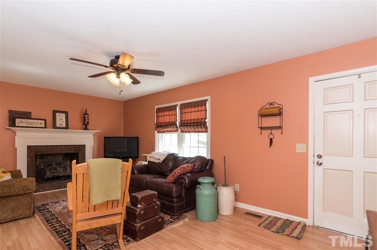 1108 Mockingbird Drive Raleigh, NC 27615 - Photo 3 of 21 a living room with furniture a fireplace and a ceiling fan