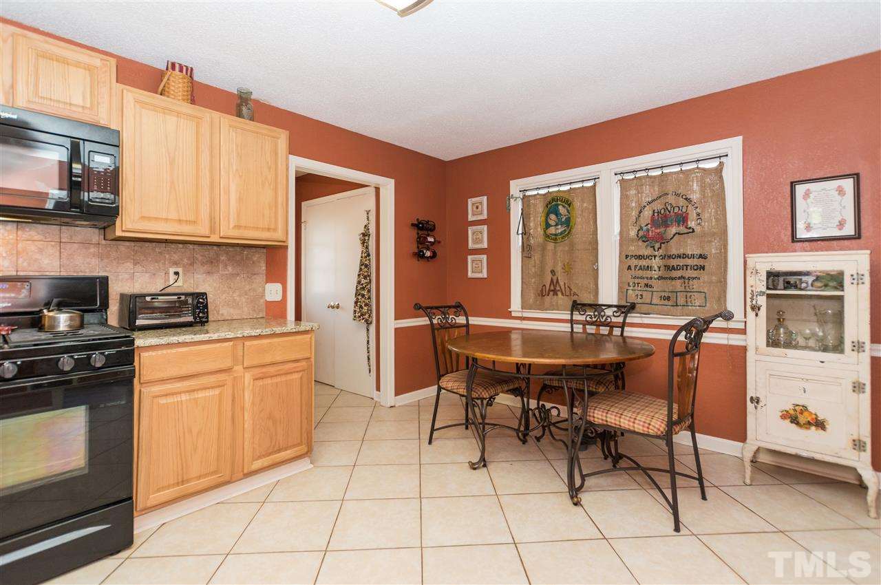 1108 Mockingbird Drive Raleigh, NC 27615 - Photo 5 of 21 a kitchen with stainless steel appliances granite countertop a stove a sink dishwasher and a dining table with chair