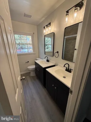 a bathroom with a sink double vanity granite tub shower and mirror