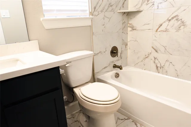 a white toilet sitting next to a bathtub