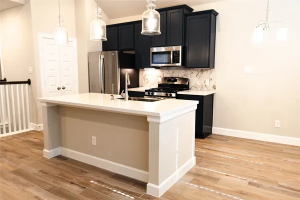 a kitchen with stainless steel appliances a stove refrigerator and microwave