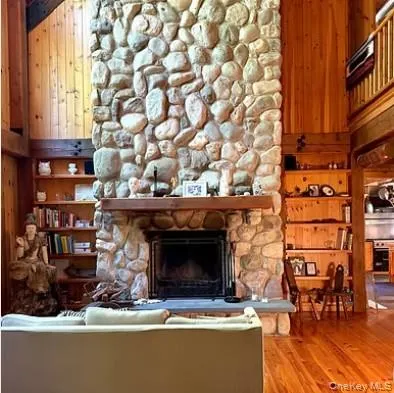 a living room with a fireplace a table and a large window