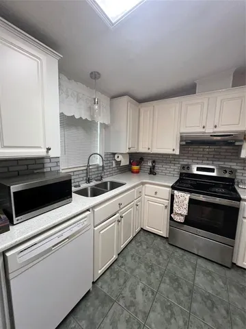 a kitchen with cabinets appliances and a window